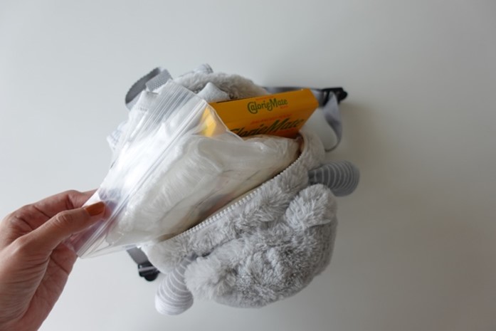 写真：ぬいぐるみリュックに着替えやお菓子などを入れているところ