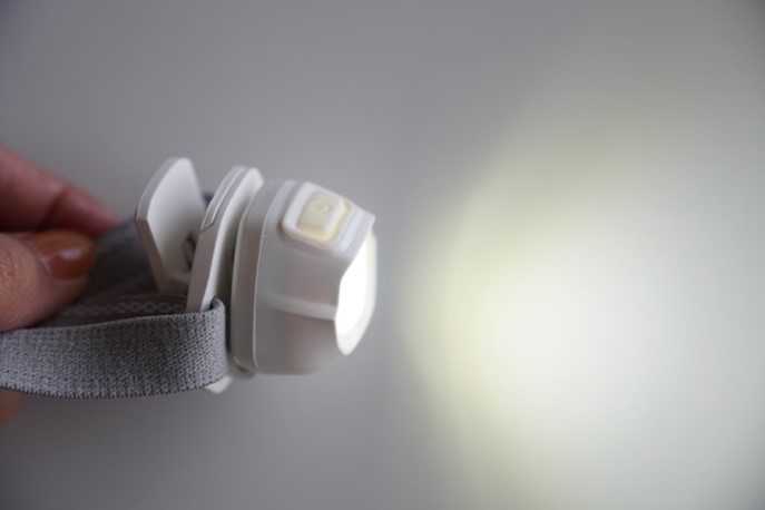 写真：コンパクトヘッドライトを手に持って使用しているところ